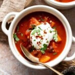 Bowls of sweet potato black bean chili topped with sour cream and cilantro