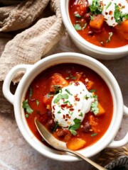 Bowls of sweet potato black bean chili topped with sour cream and cilantro