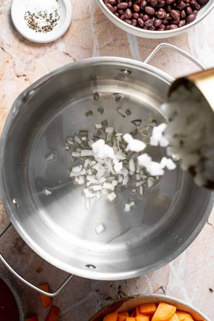 Adding diced onions to a pot
