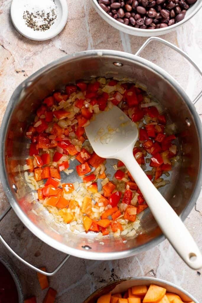 Sautéed diced onion and bell pepper in a pot