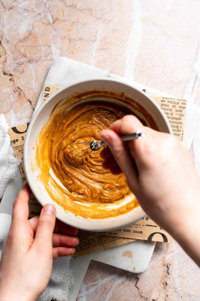 Thai peanut dressing being whisked to a smooth, pourable consistency