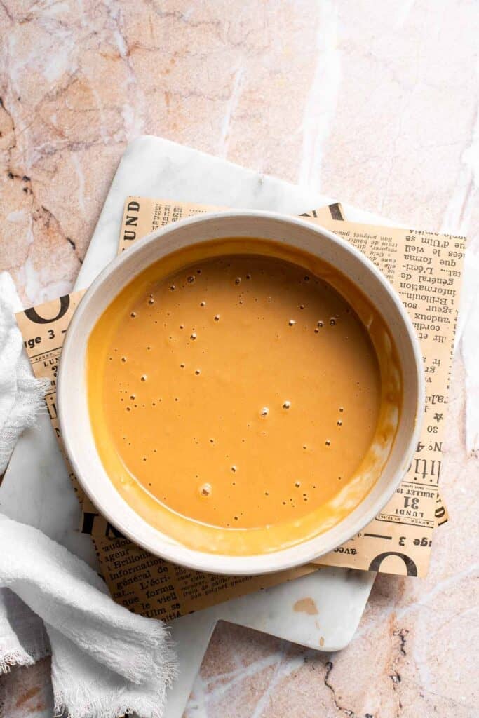 Overhead view of finished Thai peanut dressing in a white bowl