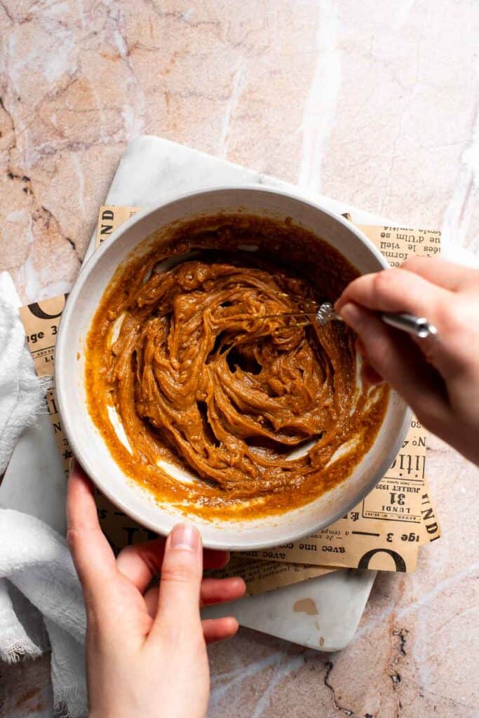 Smooth Thai peanut dressing whisked together in a white bowl