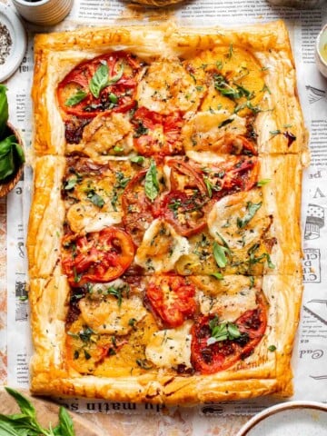 Tomato Puff Pastry Tart with mozzarella, roasted tomatoes, caramelized onions, fresh basil, and flaky golden pastry.