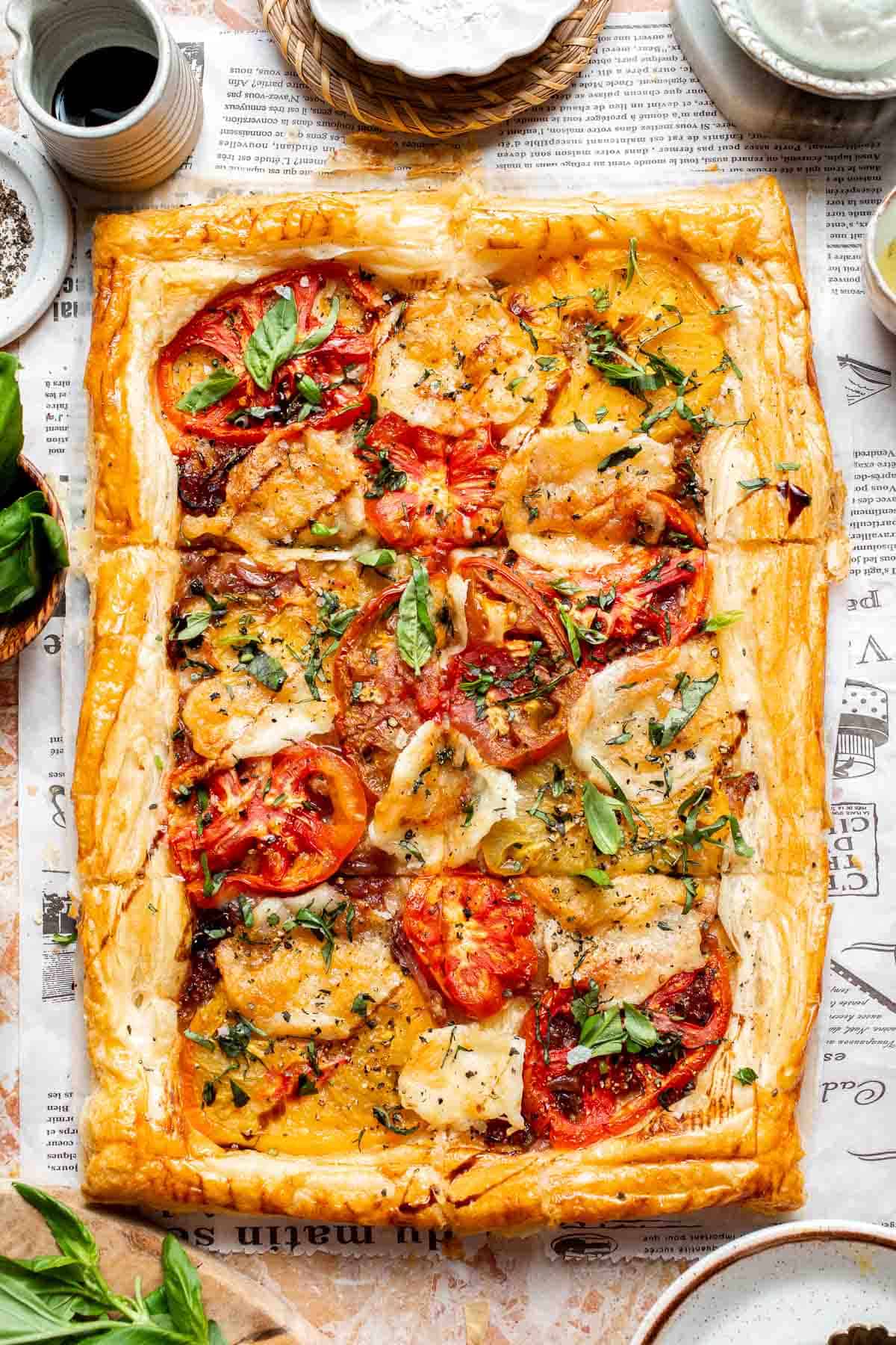 Tomato Puff Pastry Tart with mozzarella, roasted tomatoes, caramelized onions, fresh basil, and flaky golden pastry.
