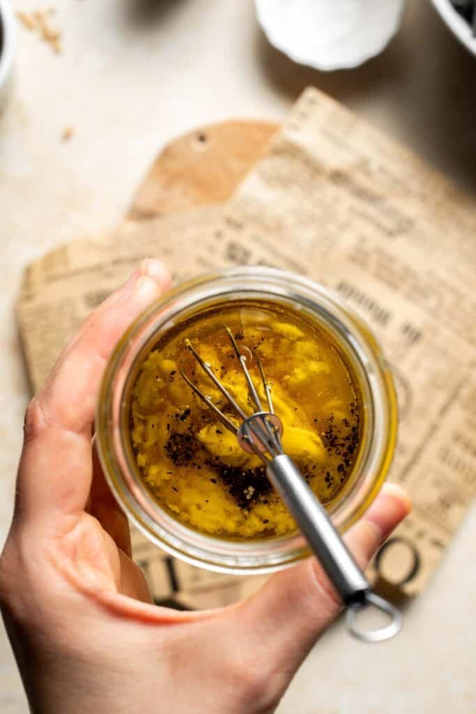 Maple Dijon dressing ingredients added to a small glass jar