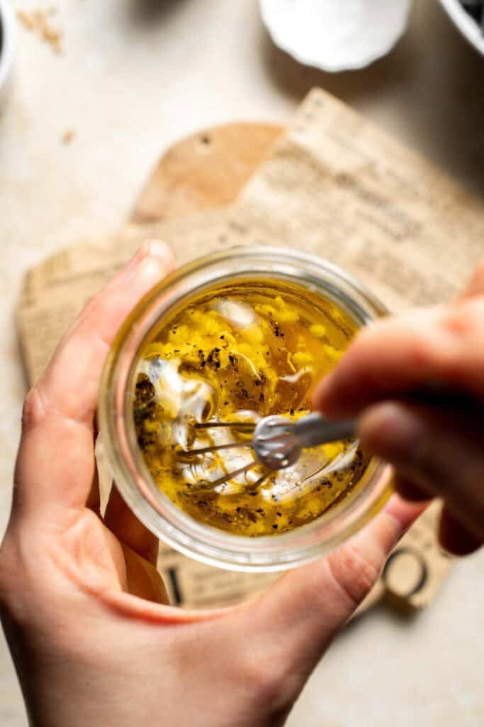 Maple Dijon dressing being whisked in a jar