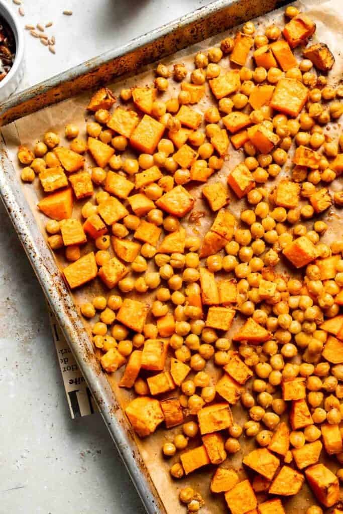Roasted sweet potatoes and chickpeas on a baking sheet, fully cooked