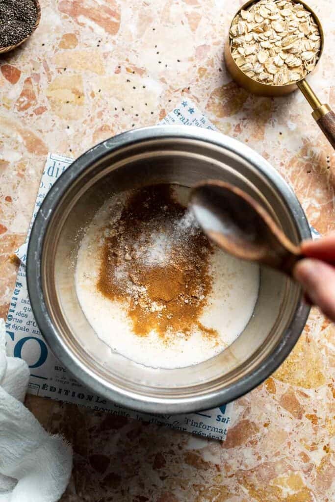 Salt being sprinkled into a bowl of protein oat mixture