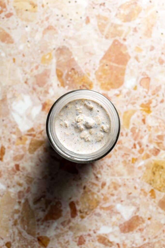 Overnight oats mixture being poured into a glass jar