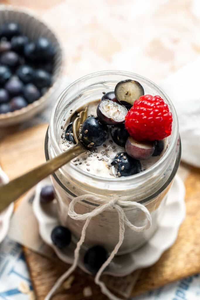 Overhead view of high protein overnight oats topped with blueberries and raspberries