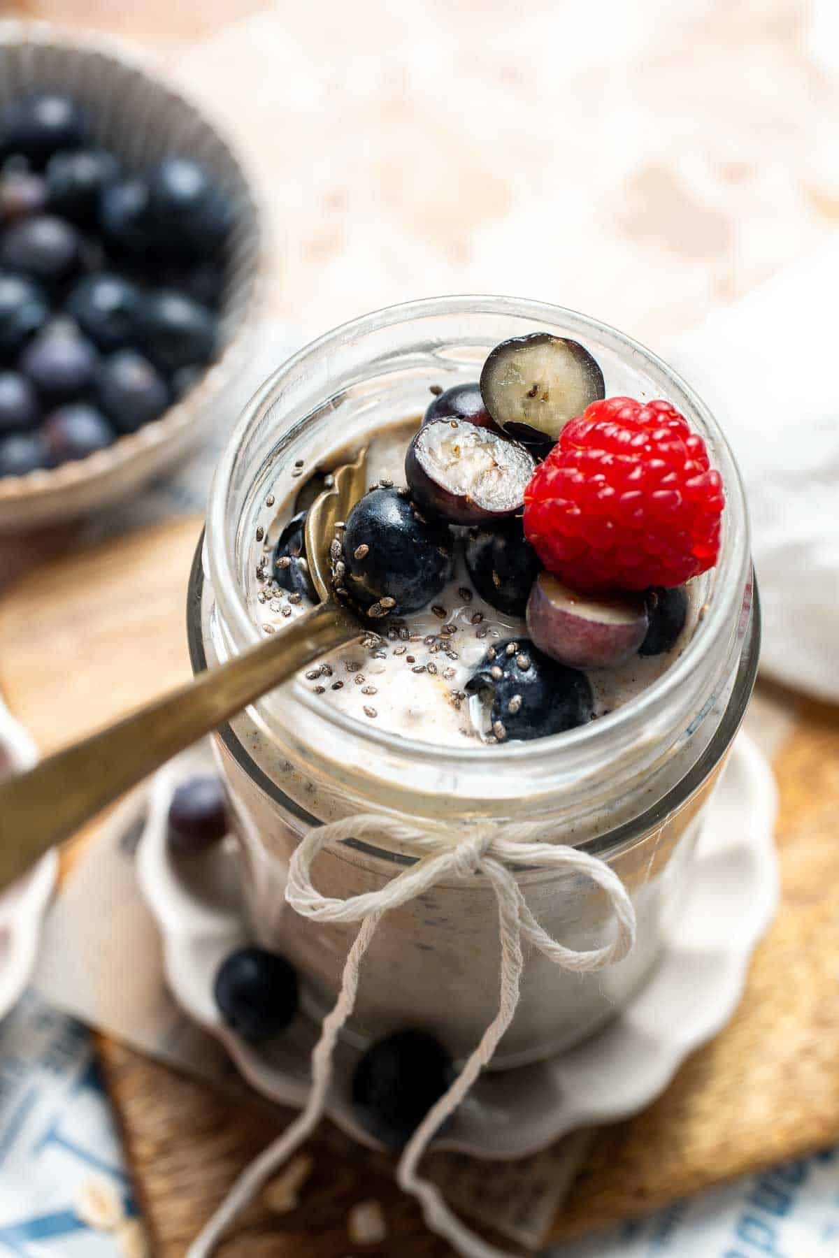 Overhead view of high protein overnight oats topped with blueberries and raspberries