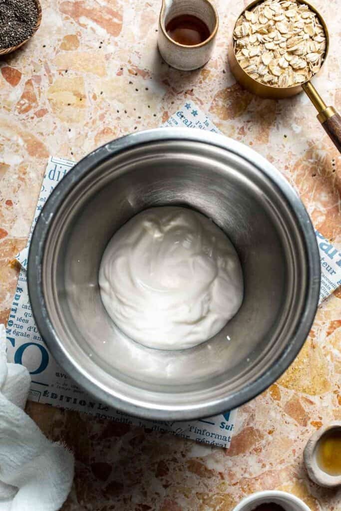 Yogurt whisked smooth in a metal mixing bowl
