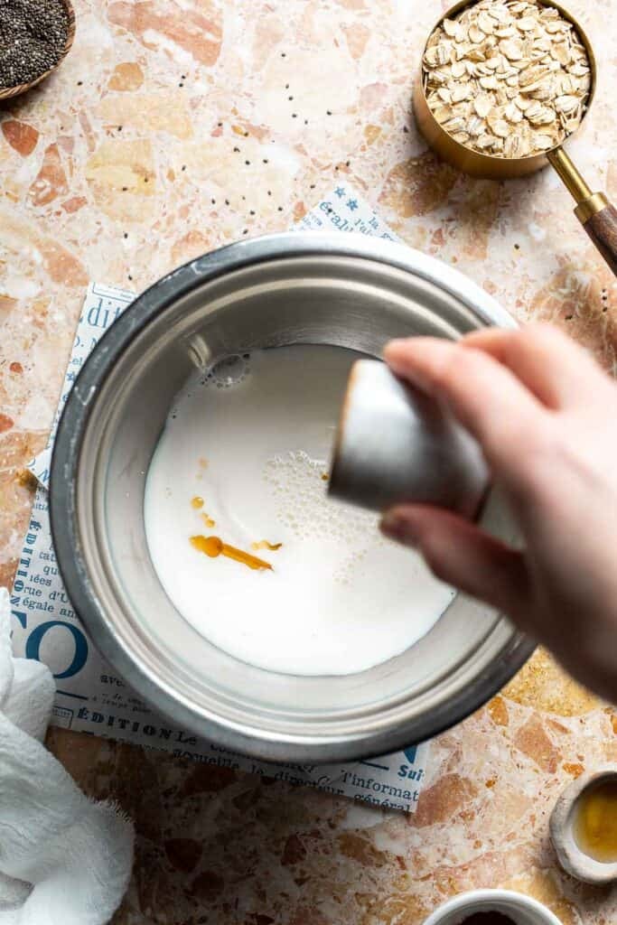 Maple syrup being poured into a bowl of yogurt and milk