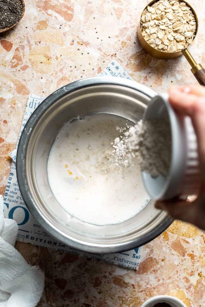 Protein powder being added to a bowl of wet ingredients