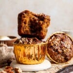 A stack of pecan pie muffins on a plate, one muffin broken in half