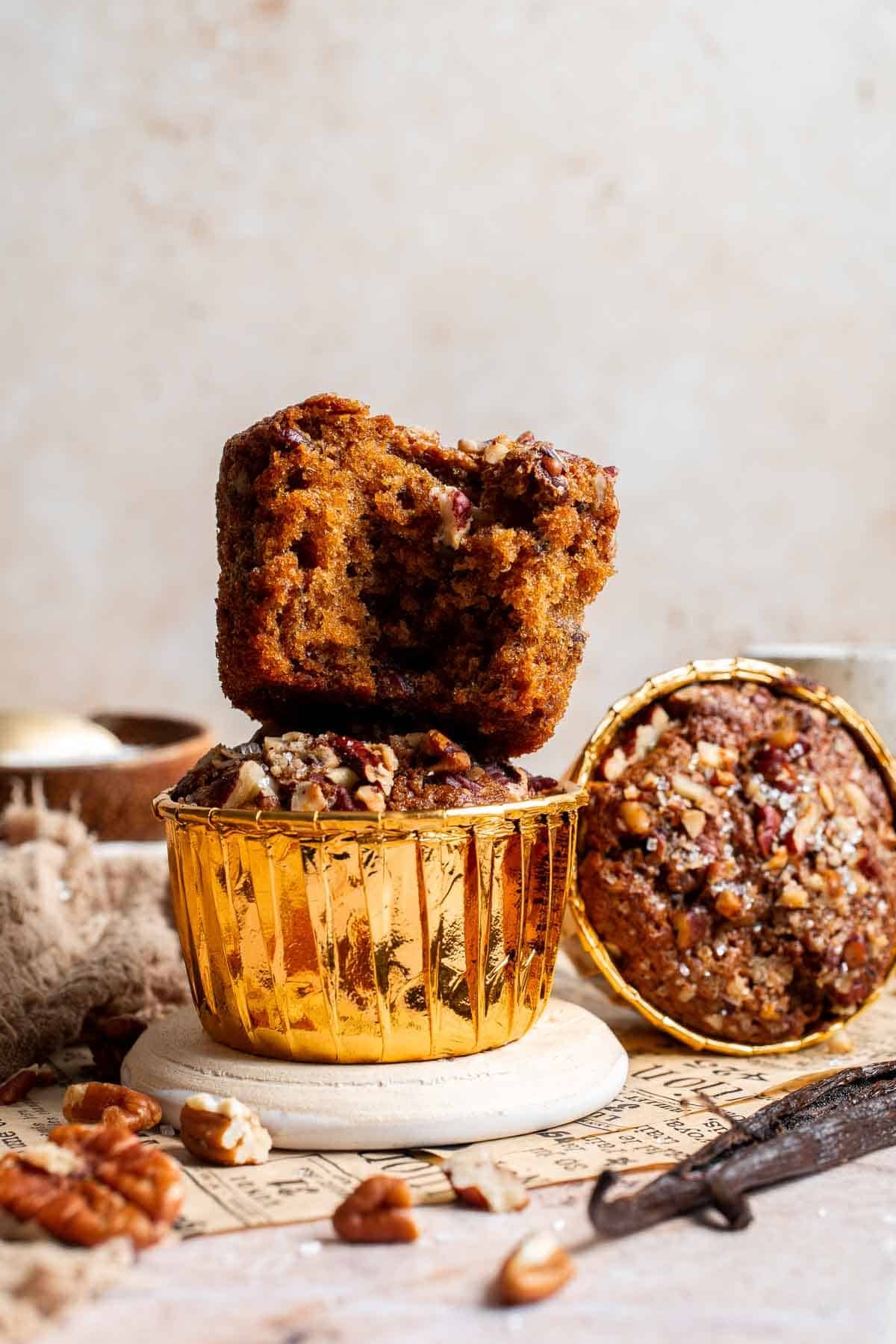 A stack of pecan pie muffins on a plate, one muffin broken in half