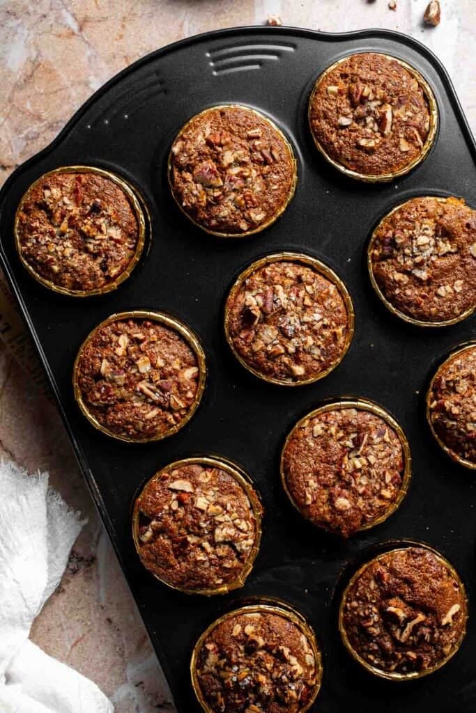 Baked pecan pie muffins in a muffin pan, golden brown