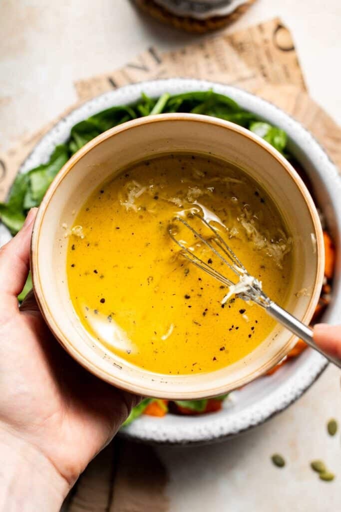 Maple Dijon dressing being whisked in a small bowl