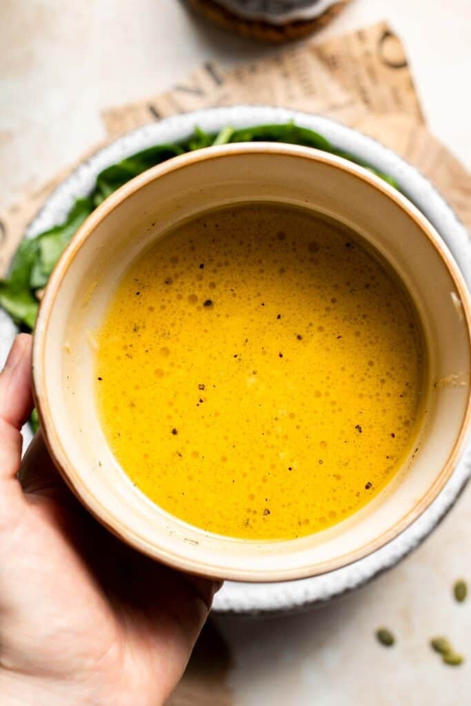 Maple Dijon dressing whisked smooth in a small bowl