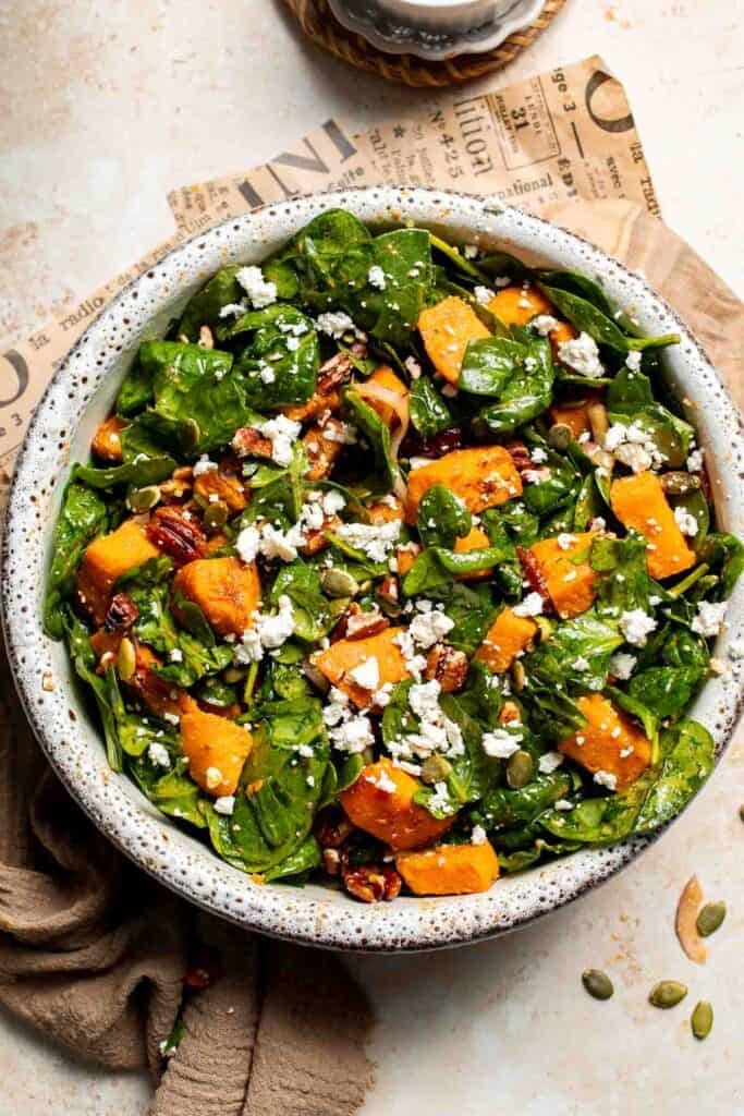 Overhead view of roasted sweet potato salad with spinach, feta, and pecans