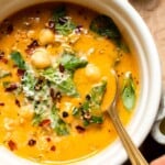 Close-up of a bowl of Tuscan chickpea soup garnished with Parmesan and herbs