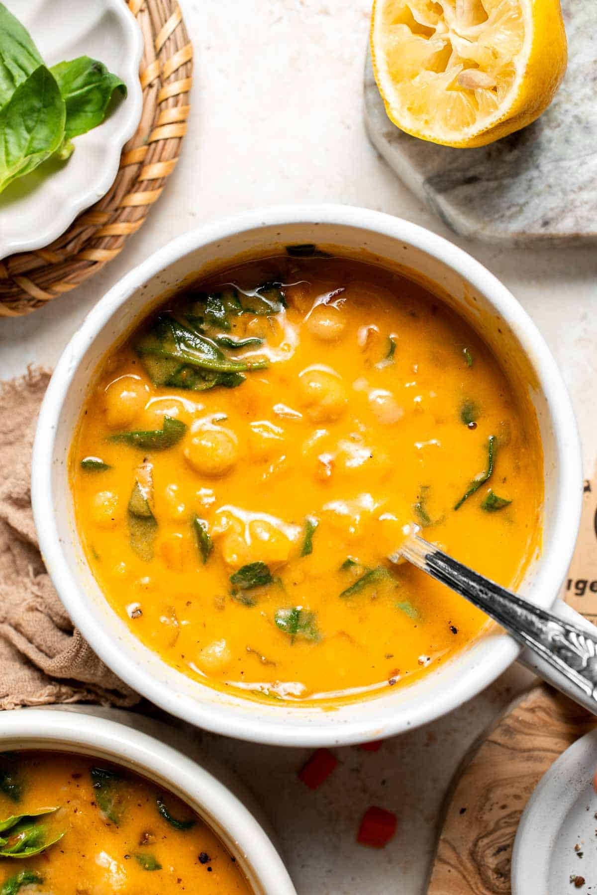 Overhead view of a bowl of Tuscan chickpea soup with a spoon