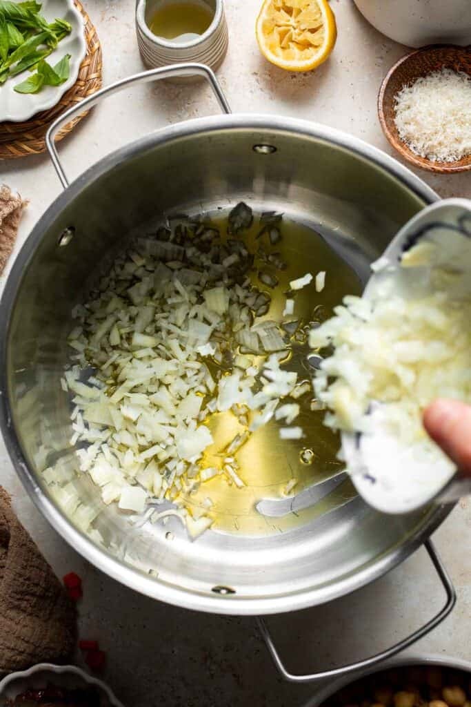 Diced onion added to a pot with olive oil
