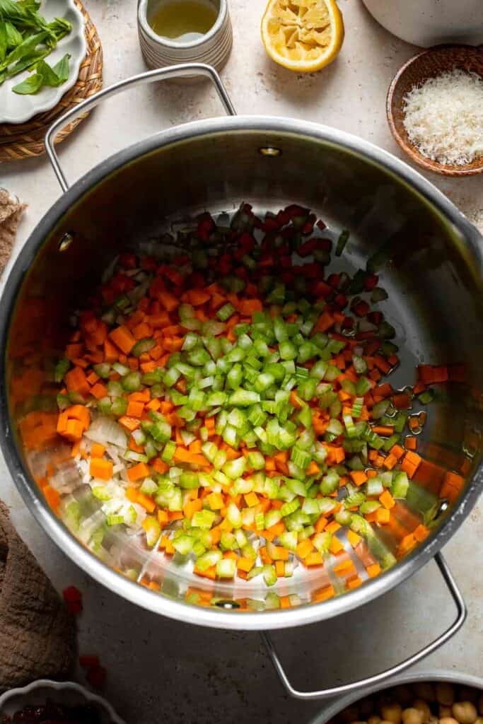 Sautéed onion, carrot, and celery cooking together in a pot