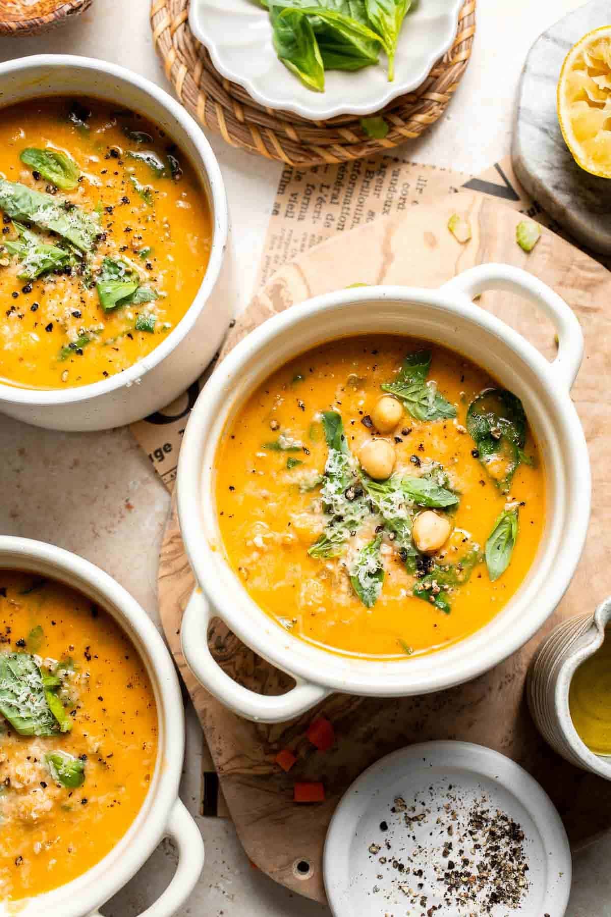 Bowls of Tuscan chickpea soup topped with Parmesan and fresh basil