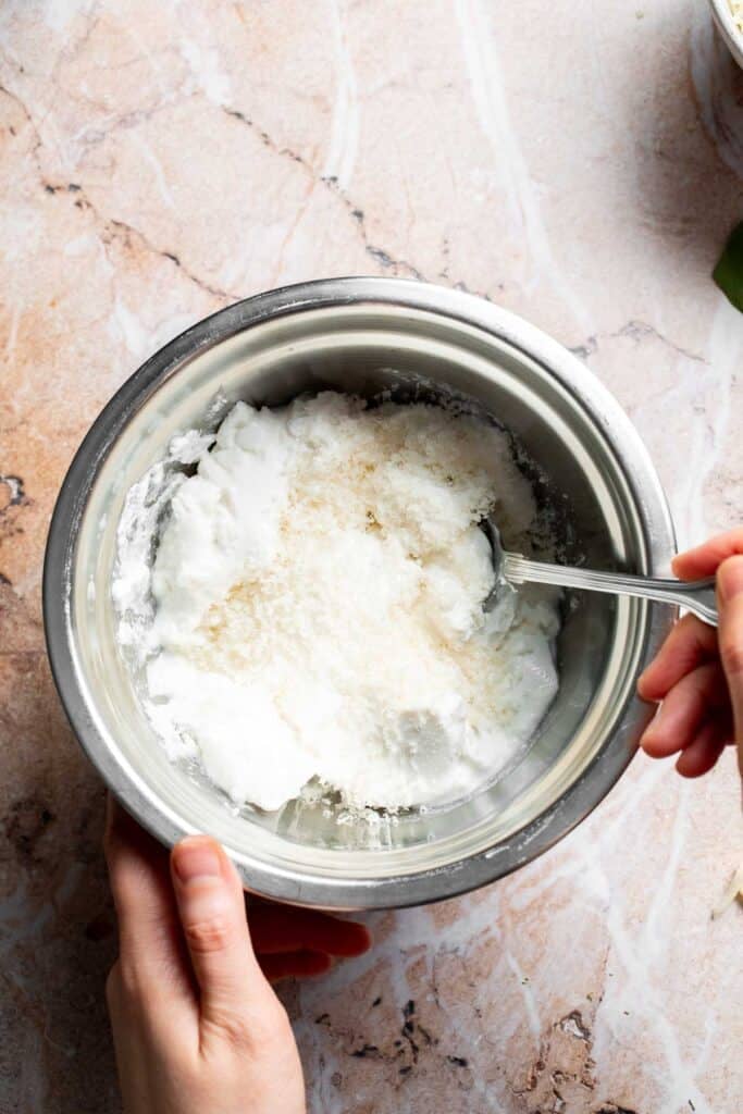 Stirring Ricotta and Parmesan cheese in a bowl