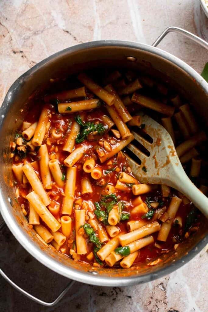Pasta and sauce mixture tossed evenly in a pot
