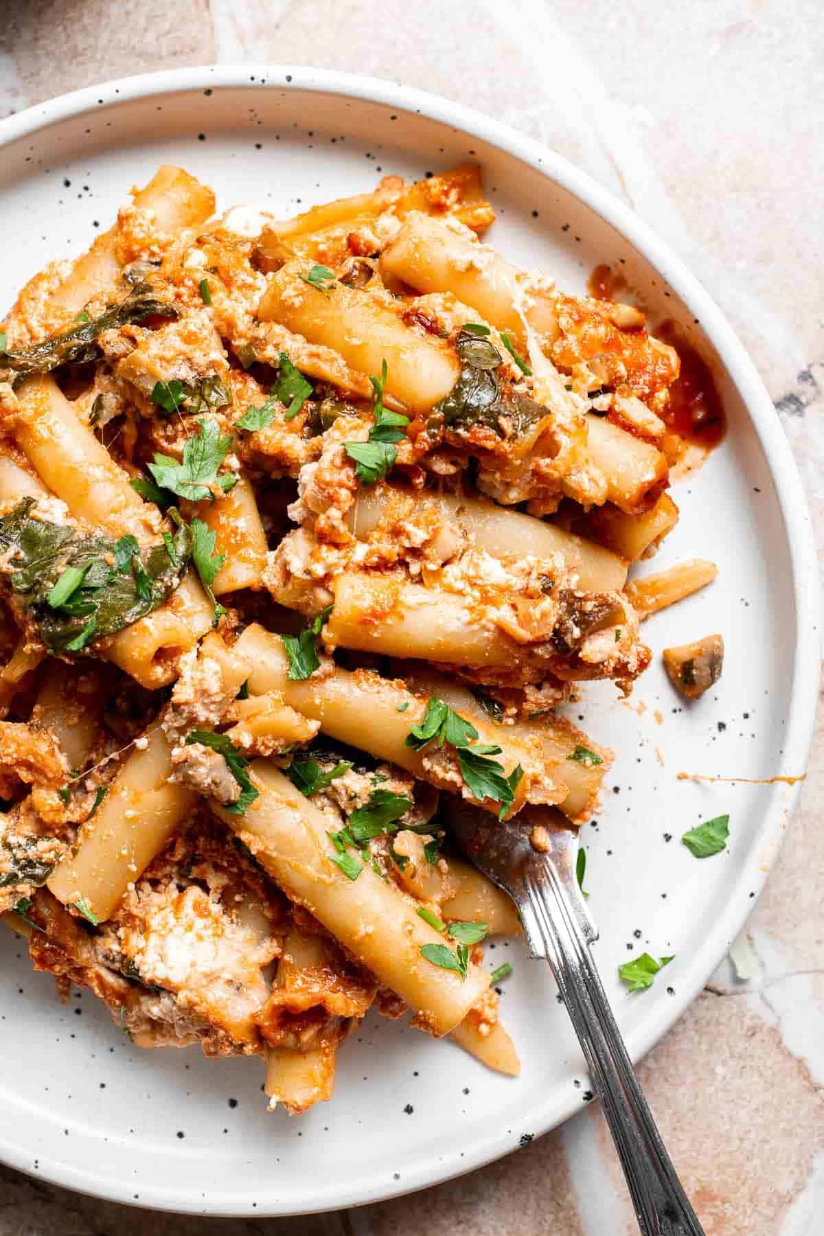 A plated serving of vegetarian baked ziti garnished with fresh herbs