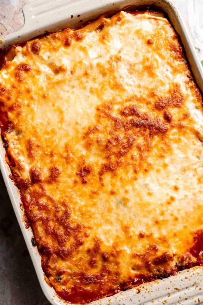 Overhead view of baked vegetarian ziti with a golden, bubbly cheese topping