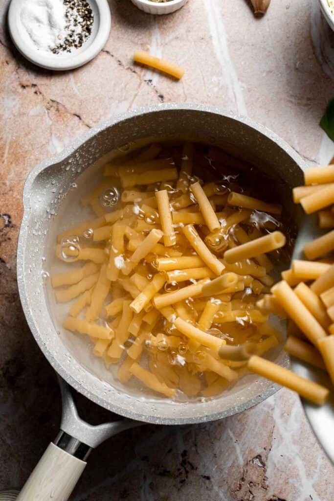 Ziti pasta being boiled in a pot of water