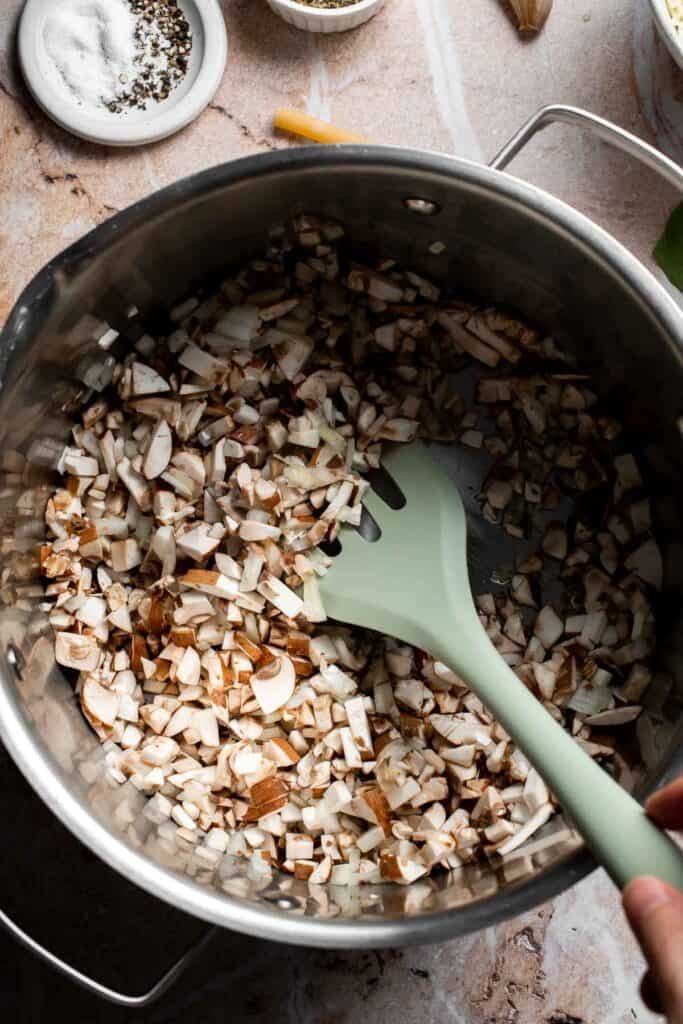 Mushrooms and onion sautéing together in a pot