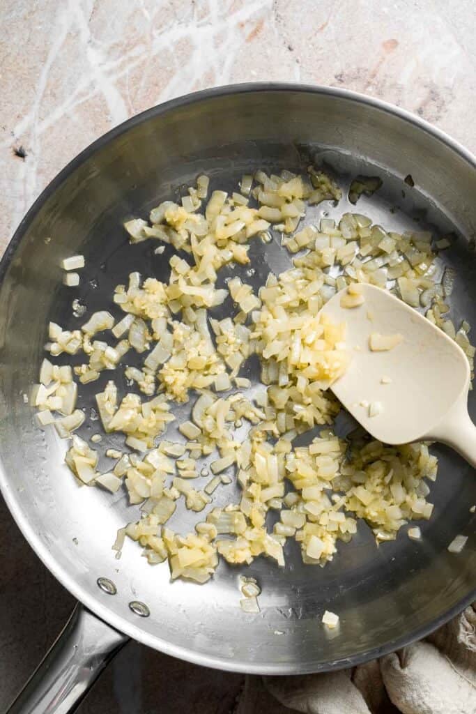 Onion and garlic sautéing together in a skillet
