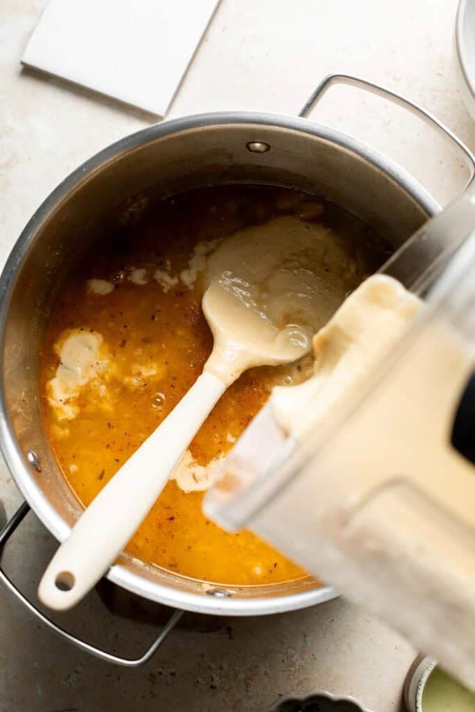 Pouring the blended chili back into the pot.