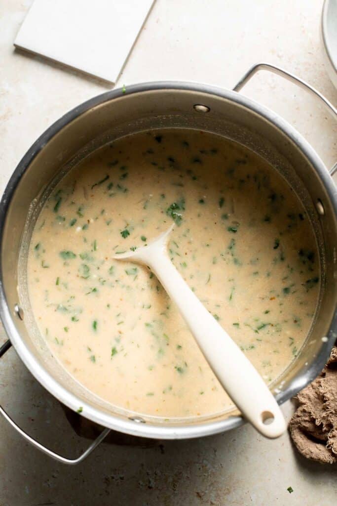 Creamy white bean chili stirred with fresh cilantro in the pot.