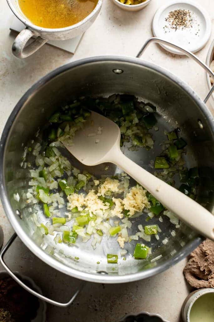 Stirring minced garlic into the sautéed onion and peppers.