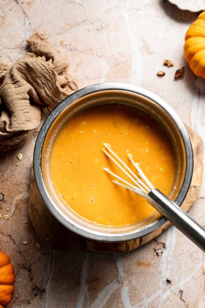 Smooth pumpkin and egg mixture whisked together in a bowl