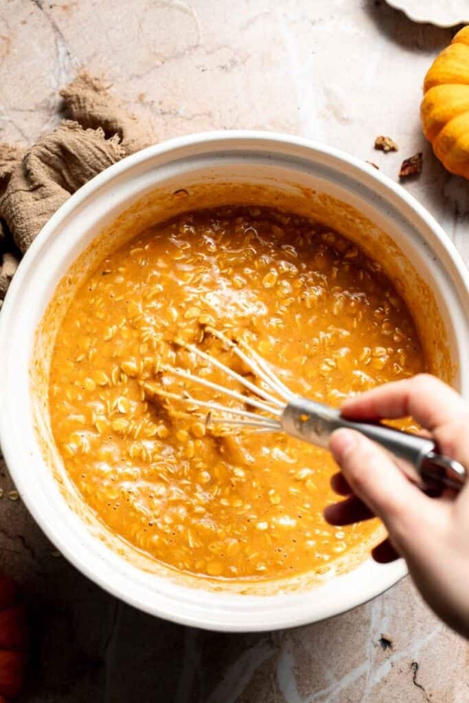 Pumpkin oatmeal batter being whisked together in a mixing bowl