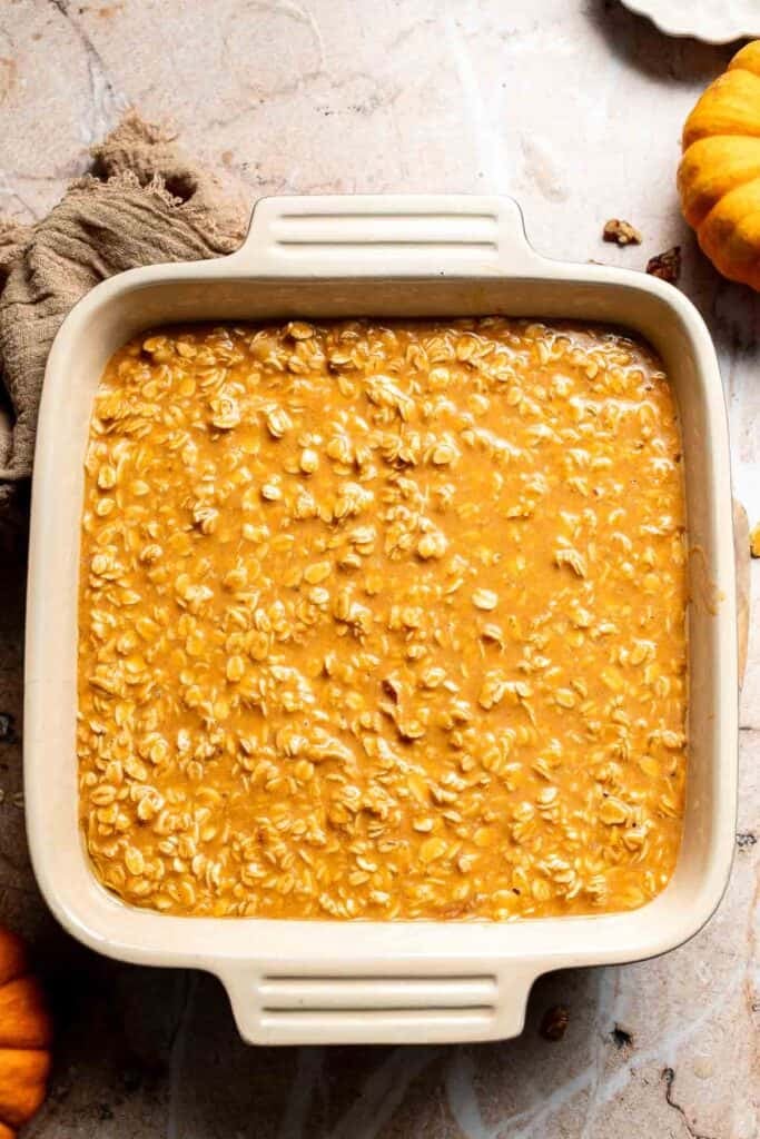 Pumpkin oatmeal batter spread evenly in a square baking dish