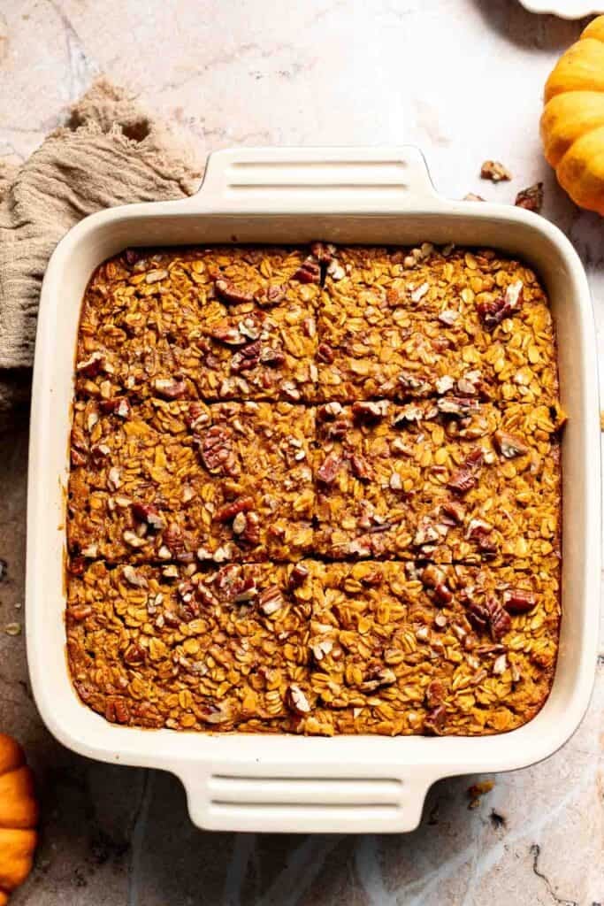 Baked pumpkin oatmeal in a baking dish, sliced into squares