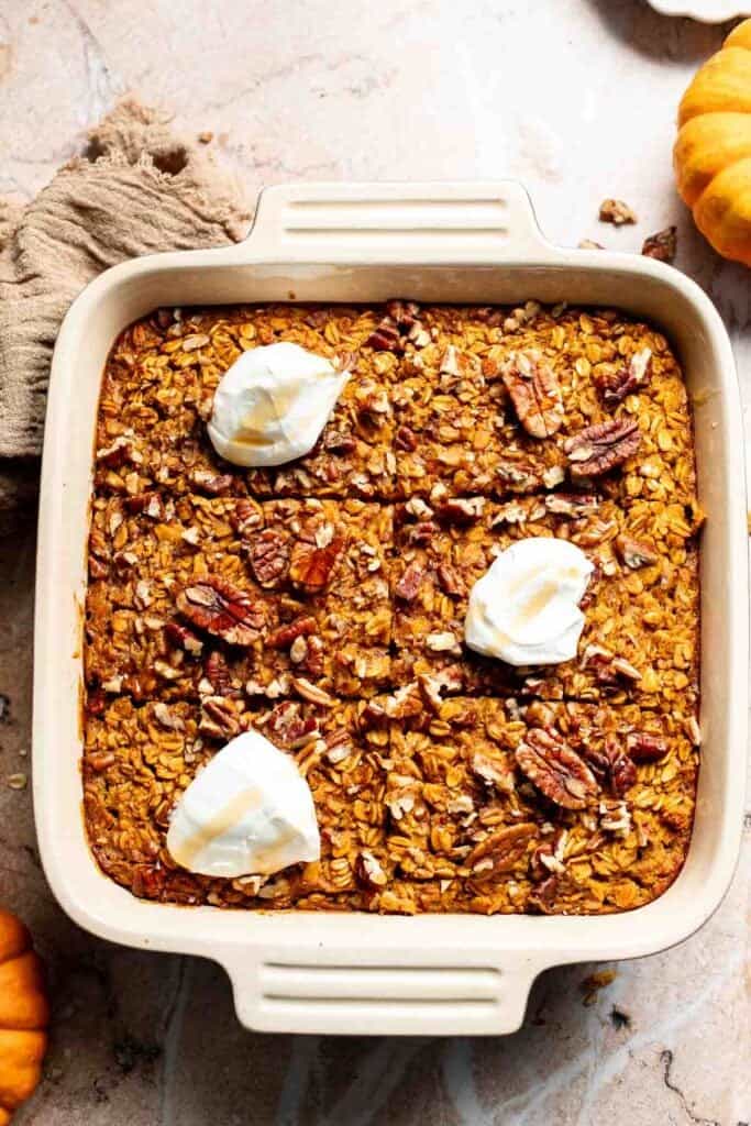 Pumpkin baked oatmeal drizzled with maple syrup and topped with Greek yogurt and pecans