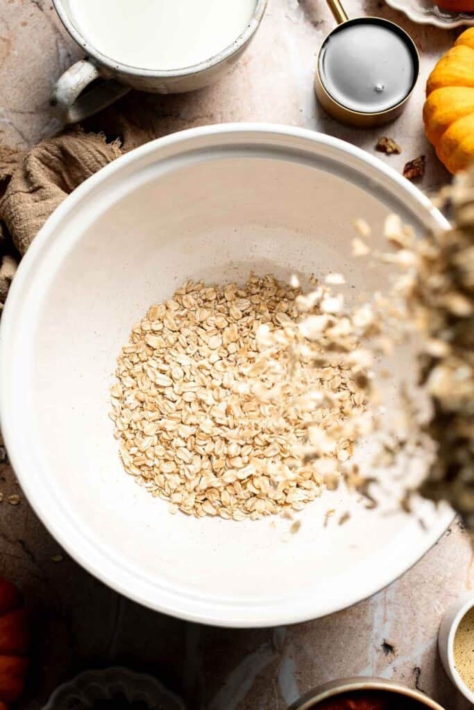 Old-fashioned rolled oats in a large white mixing bowl
