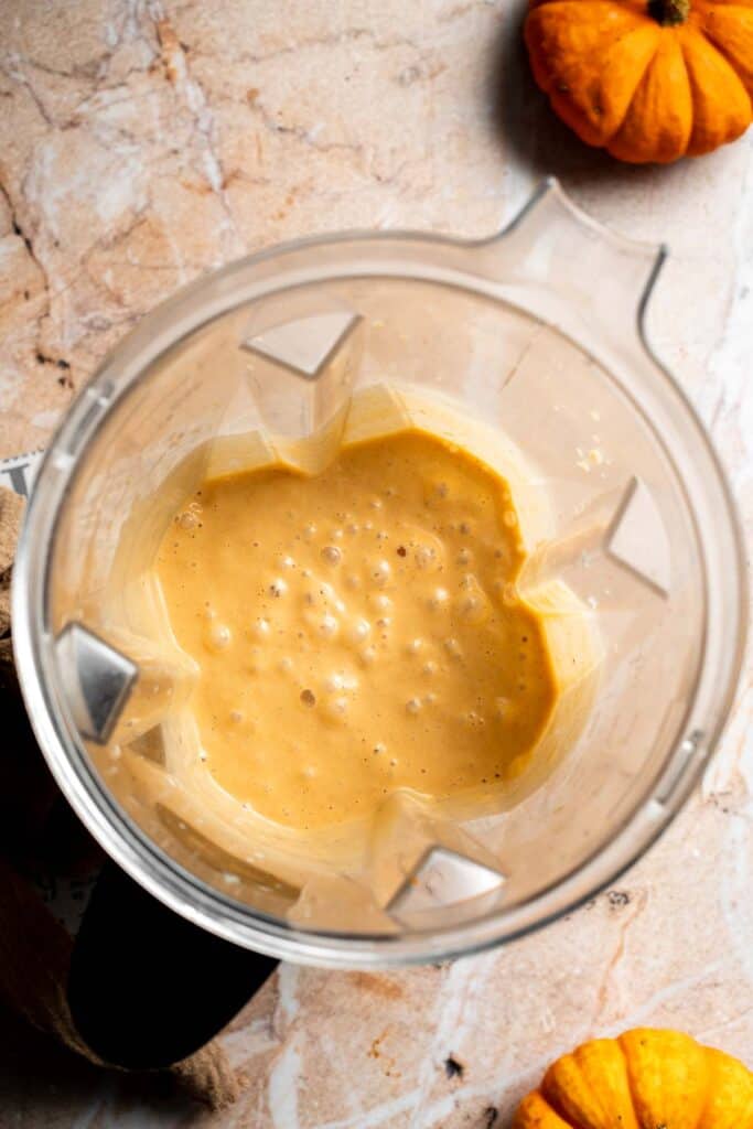 Pumpkin pie smoothie blended until smooth and creamy in a blender, shown from above.