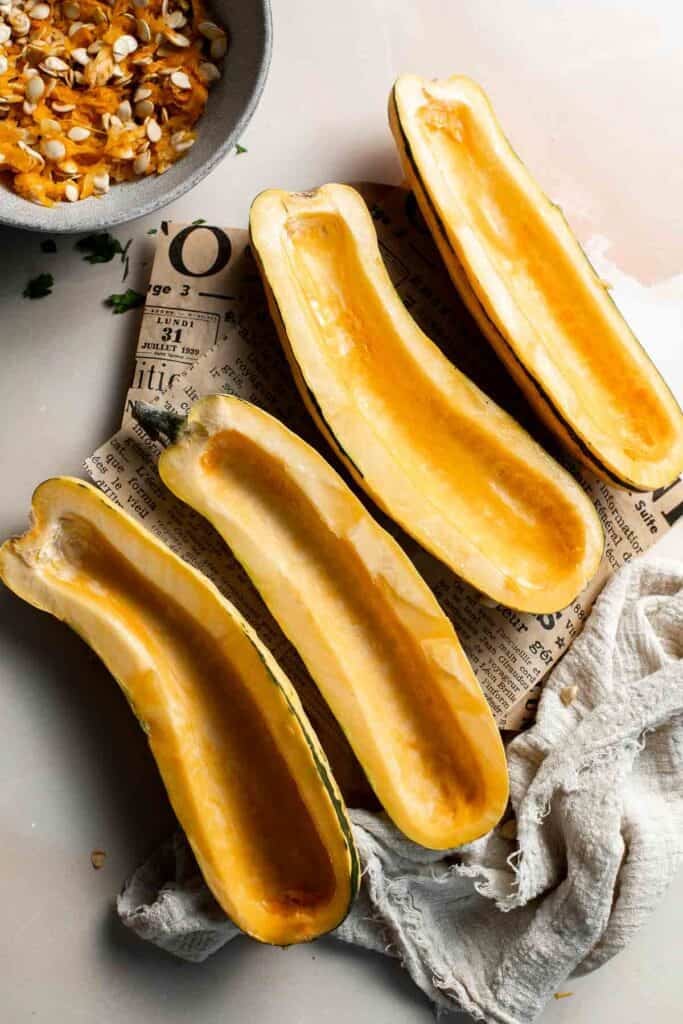 Delicata squash halves with the seeds removed.