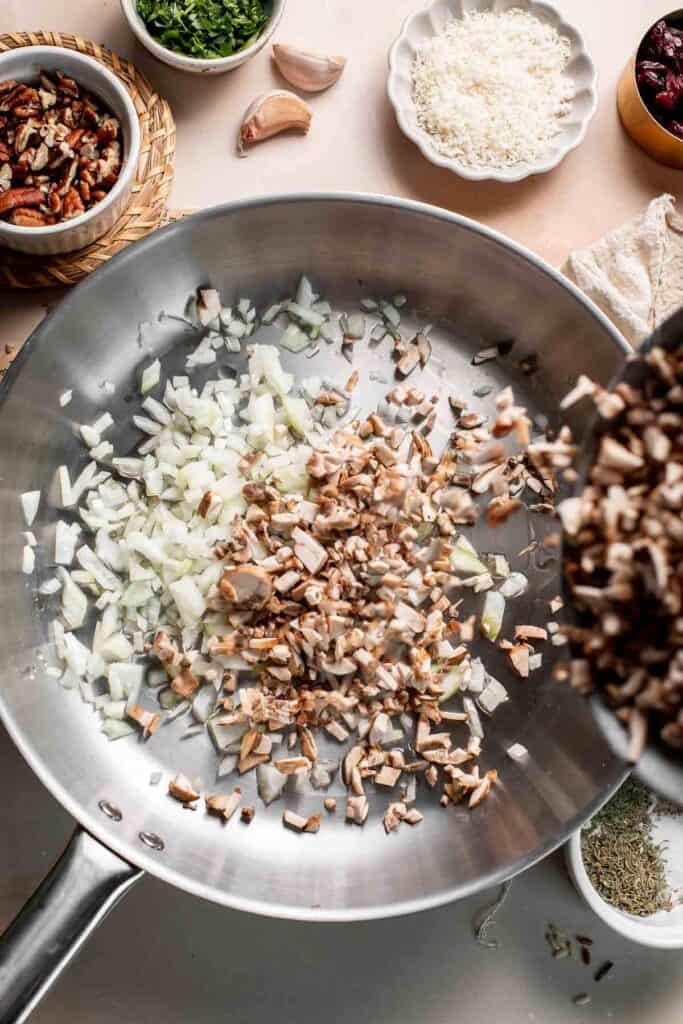 Chopped cremini mushrooms added to the diced onion in the skillet.