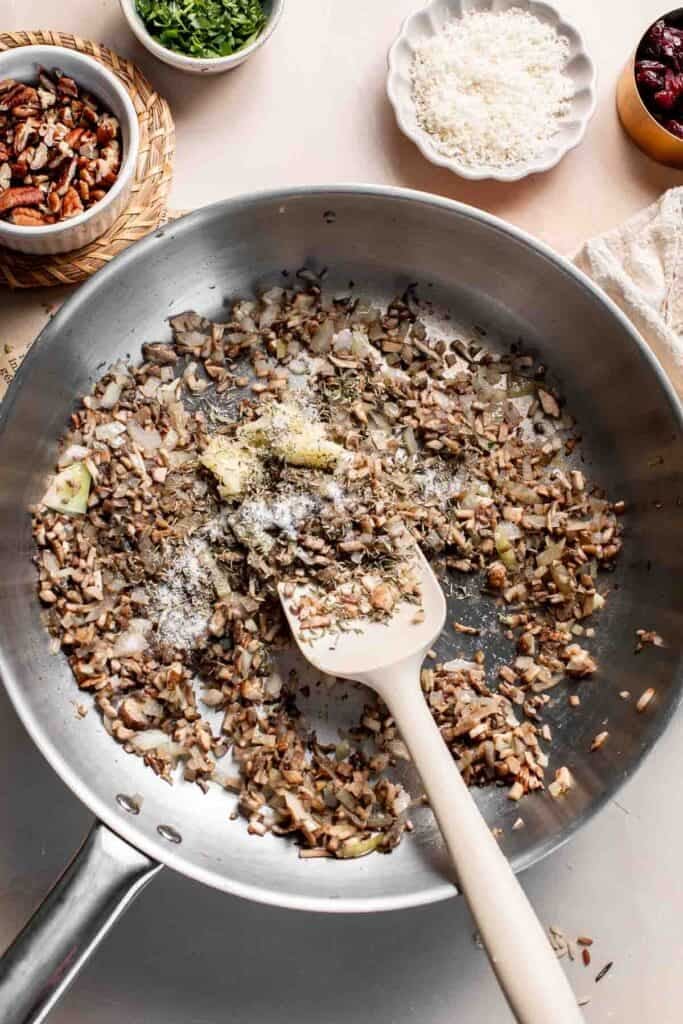 Garlic, dried herbs, and salt on top of the mushroom mixture before stirring.